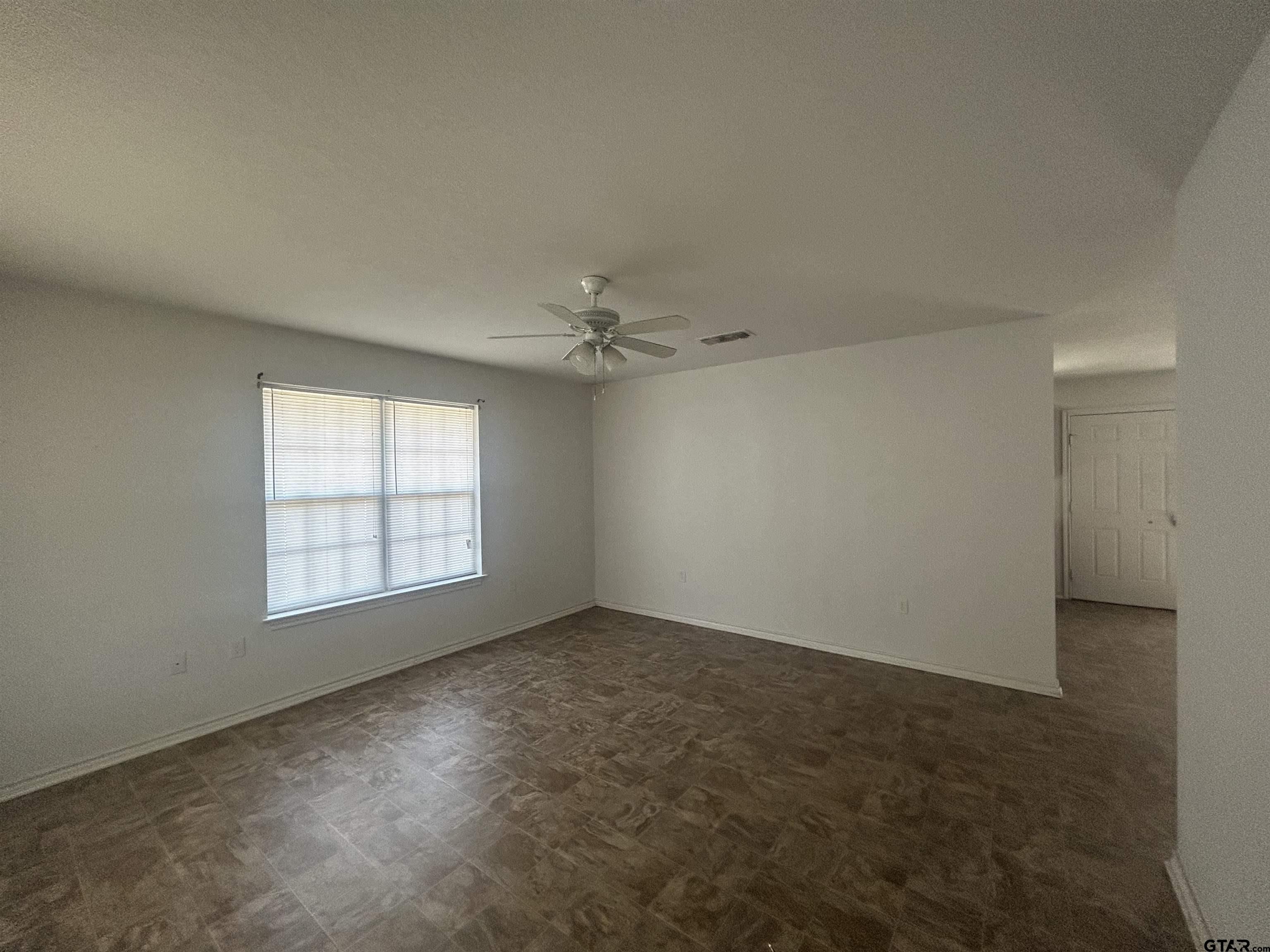 803 Sims Avenue Jacksonville, TX 75766 - Photo 8 of 18 an empty room with chandelier fan and windows