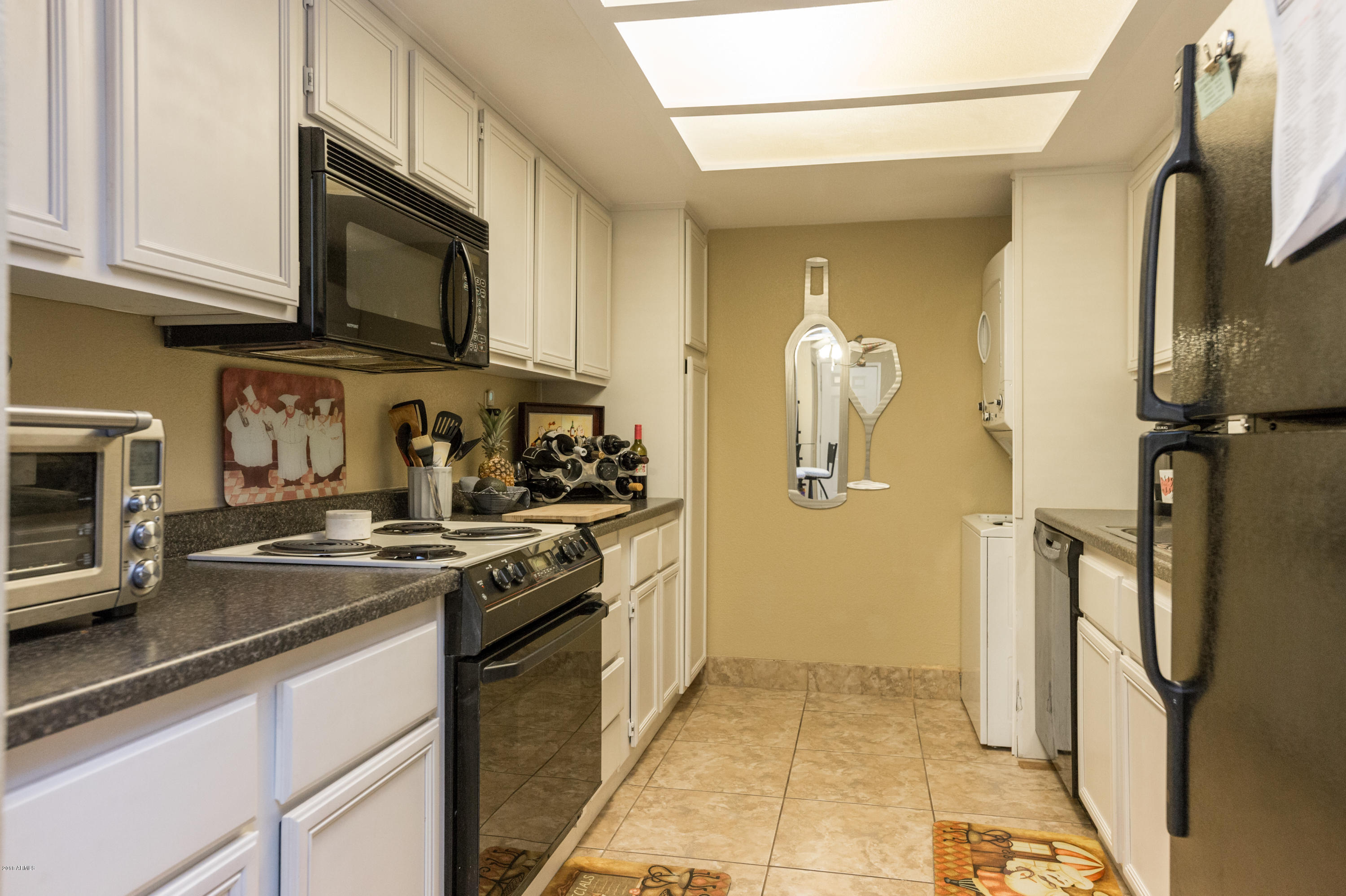 3825 East Camelback Road, Unit 249 Phoenix, AZ 85018 - Photo 11 of 30 a kitchen with stainless steel appliances granite countertop a refrigerator stove and microwave
