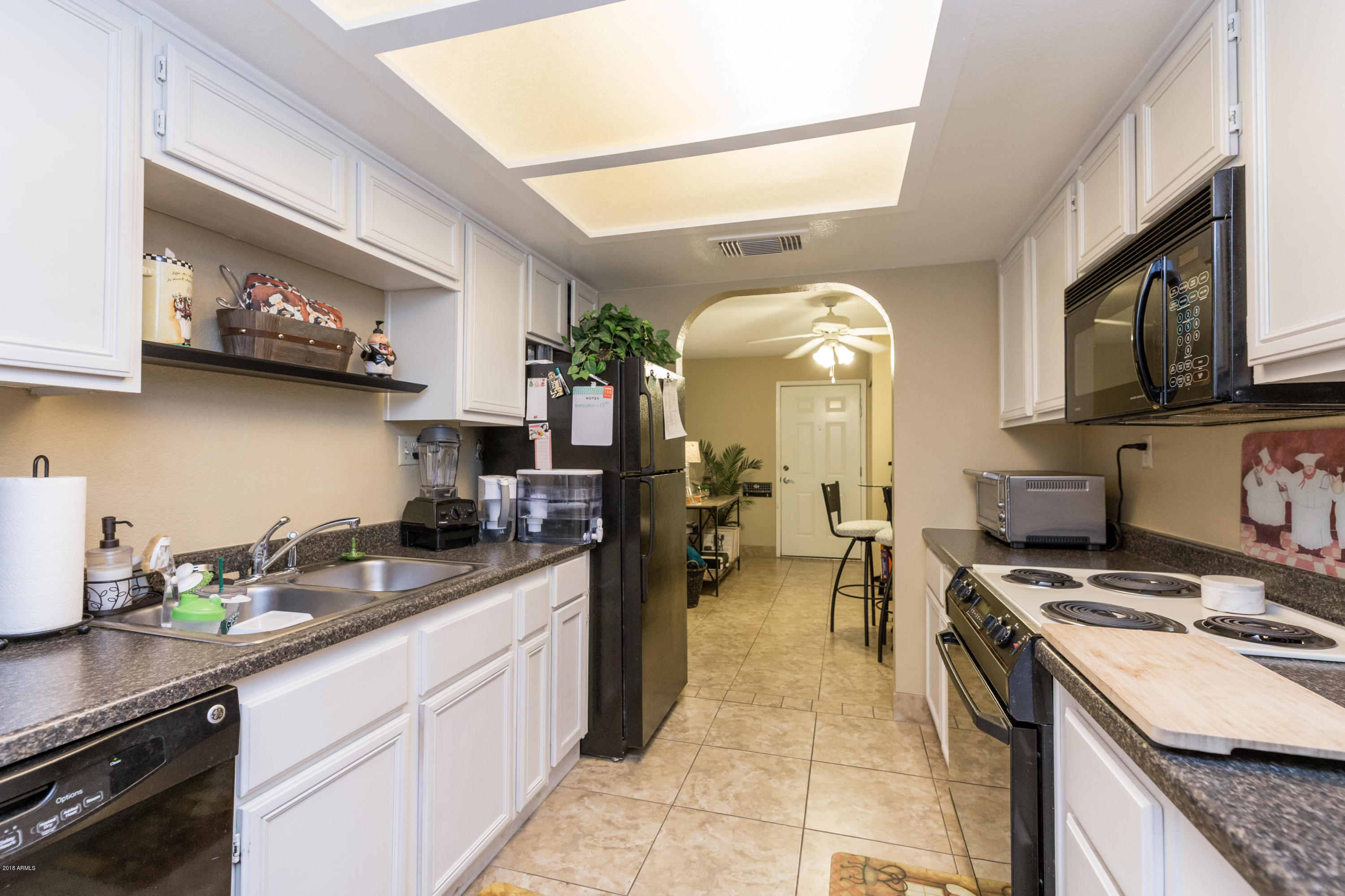 3825 East Camelback Road, Unit 249 Phoenix, AZ 85018 - Photo 13 of 30 a kitchen with stainless steel appliances granite countertop a stove a sink and a microwave