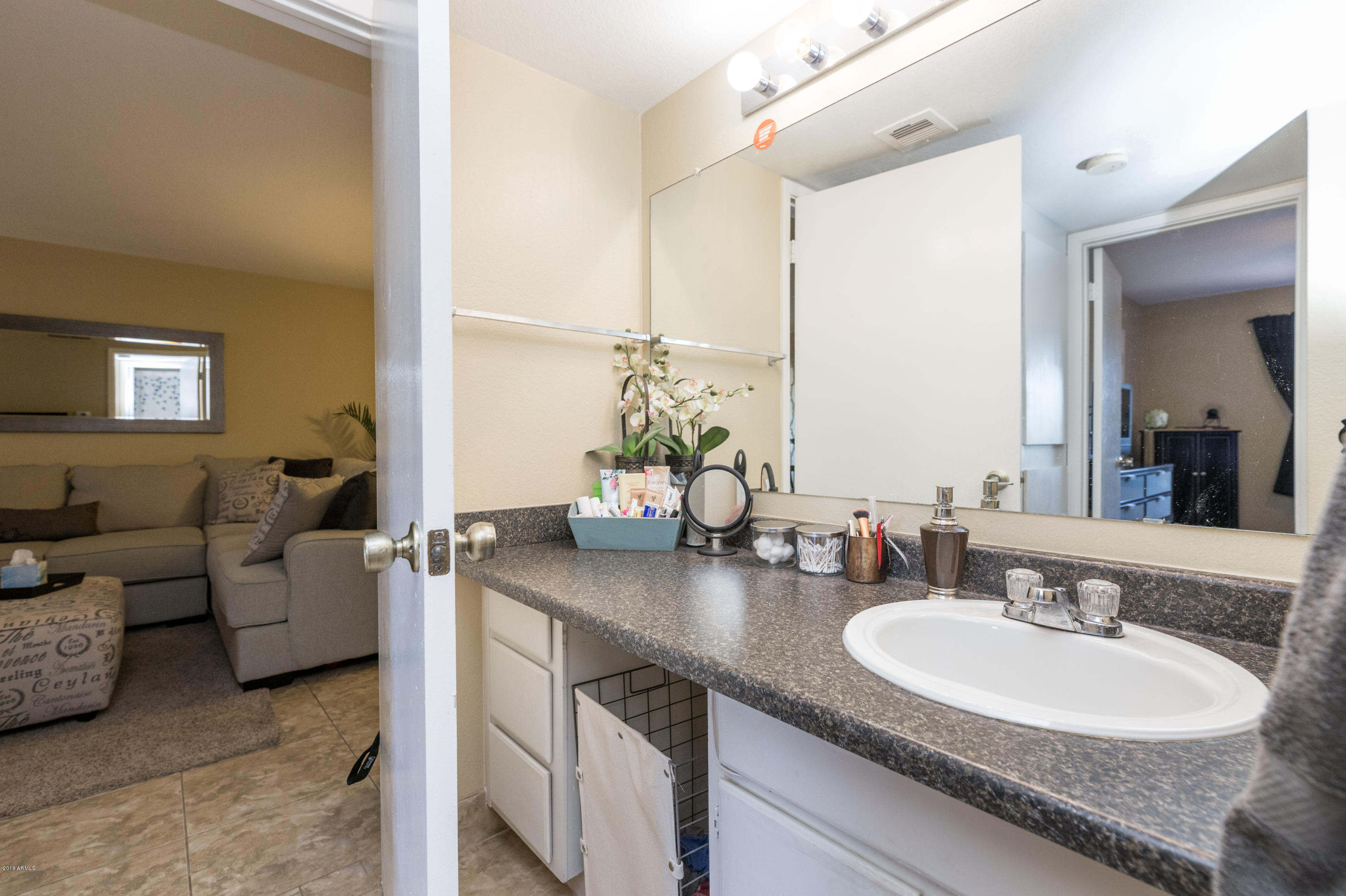 3825 East Camelback Road, Unit 249 Phoenix, AZ 85018 - Photo 16 of 30 a bathroom with a granite countertop sink a mirror and a