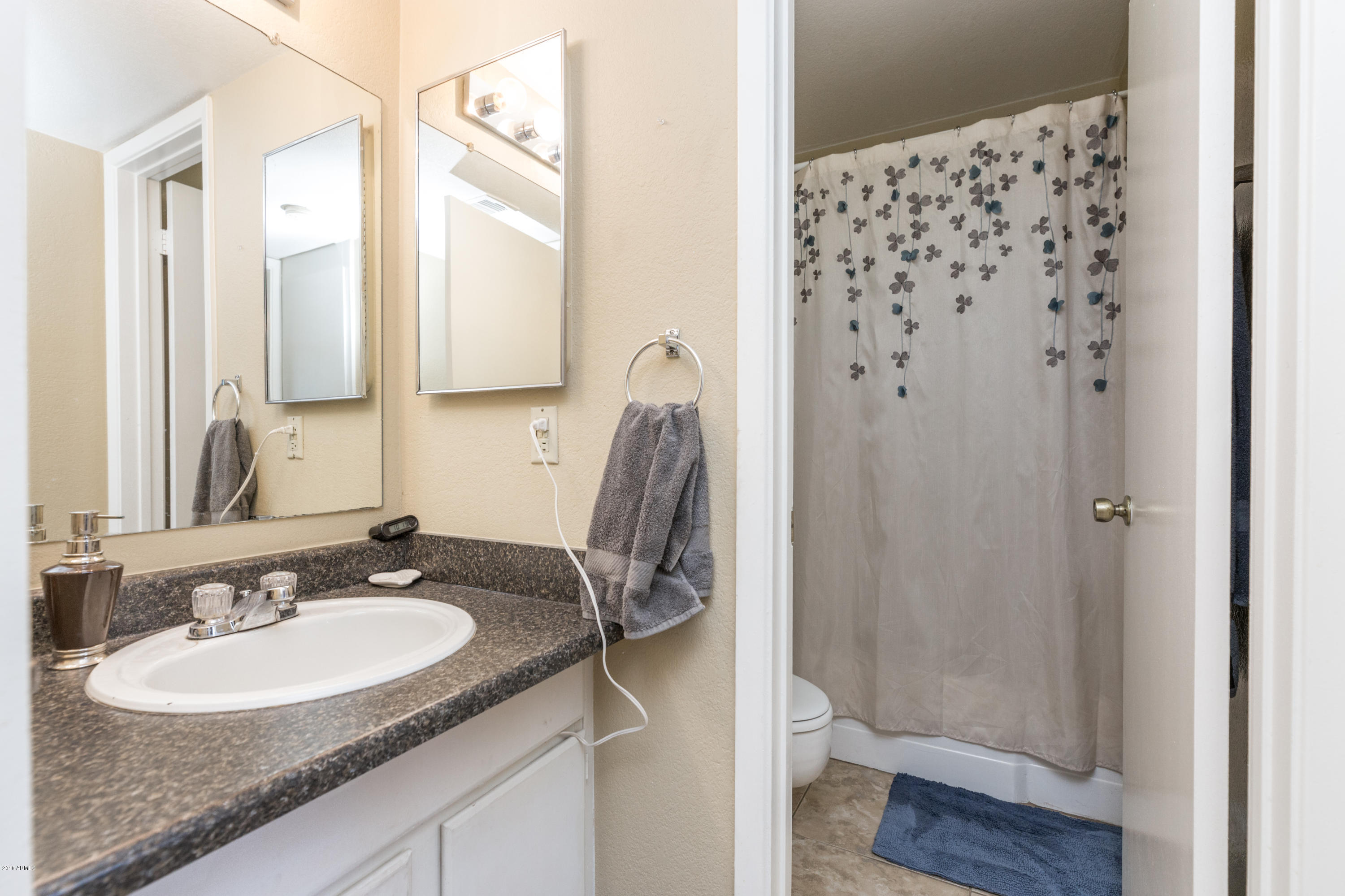 3825 East Camelback Road, Unit 249 Phoenix, AZ 85018 - Photo 17 of 30 a bathroom with a sink and a mirror