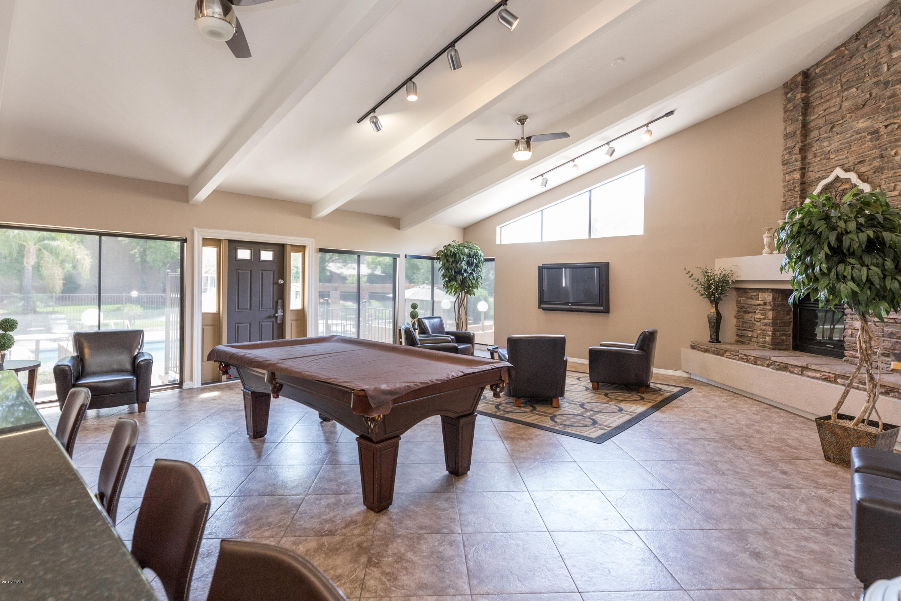 3825 East Camelback Road, Unit 249 Phoenix, AZ 85018 - Photo 25 of 30 a living room with couches a flat screen tv and kitchen view