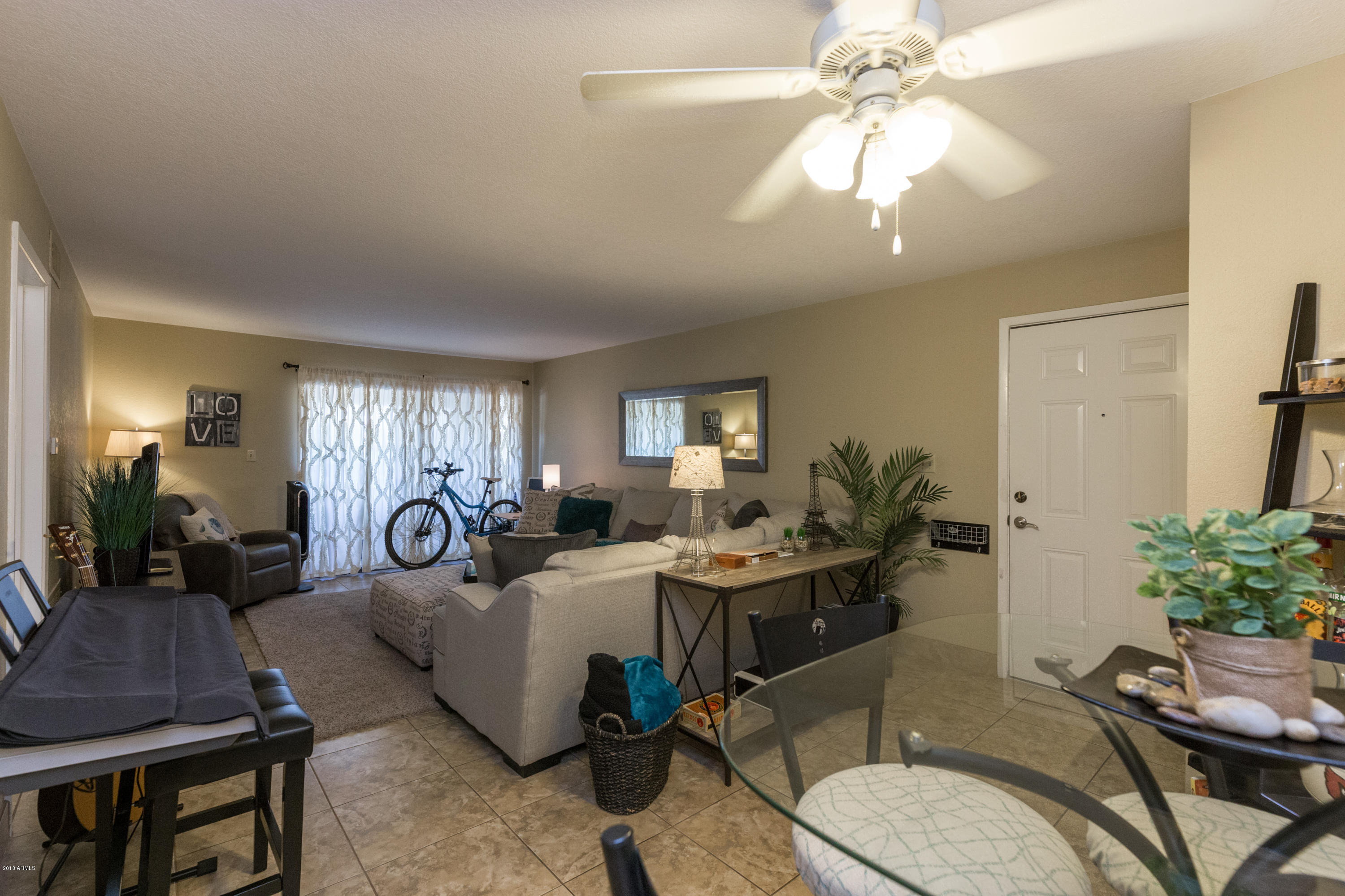 3825 East Camelback Road, Unit 249 Phoenix, AZ 85018 - Photo 8 of 30 a living room with furniture a chandelier and a dining table