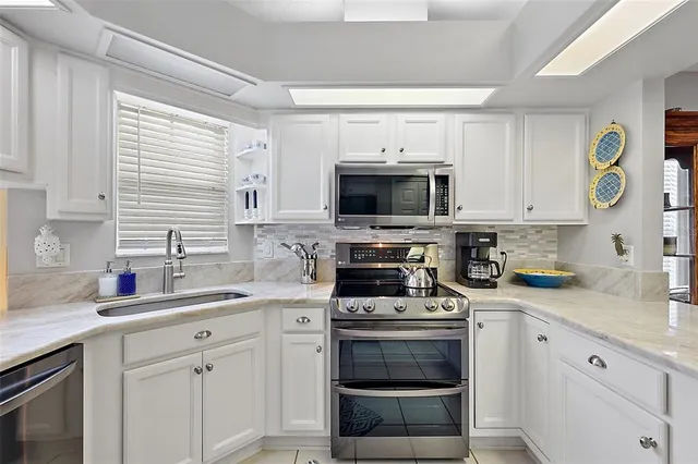 a view of a kitchen with dining area a sink stove and wooden floor
