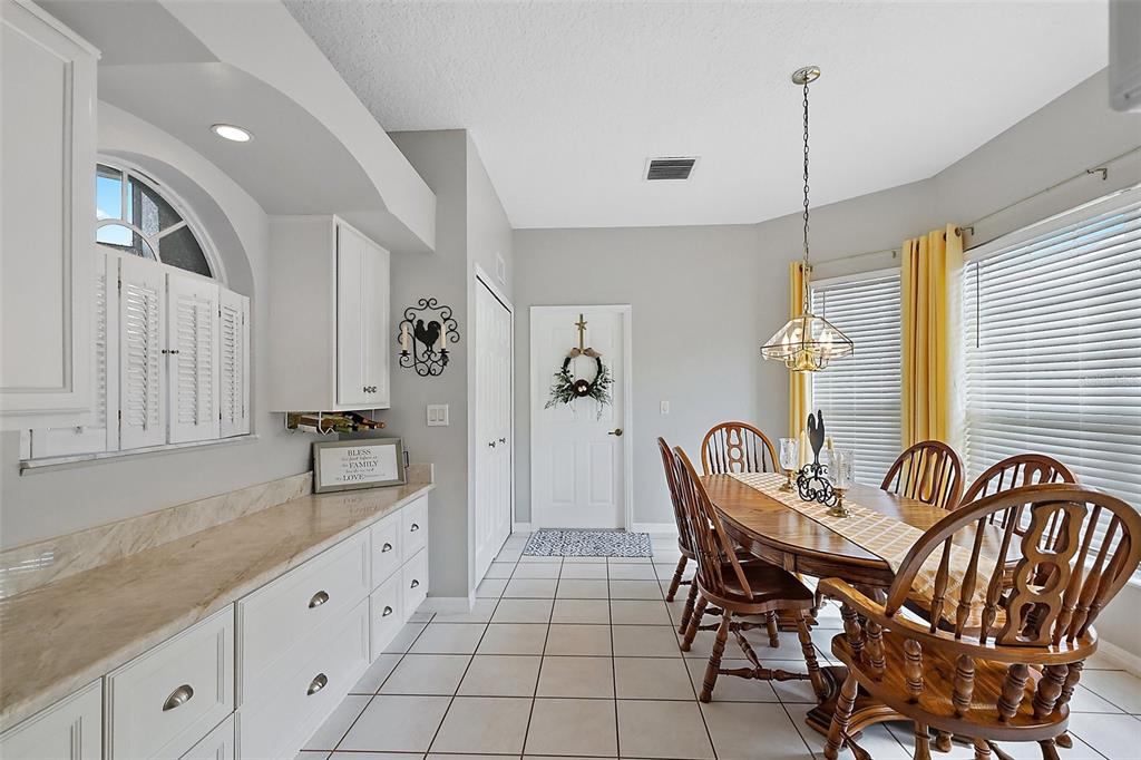 3584 Tropical Seas Loop Tavares, FL 32778 - Photo 18 of 49 a view of a kitchen with dining area a sink stove and wooden floor