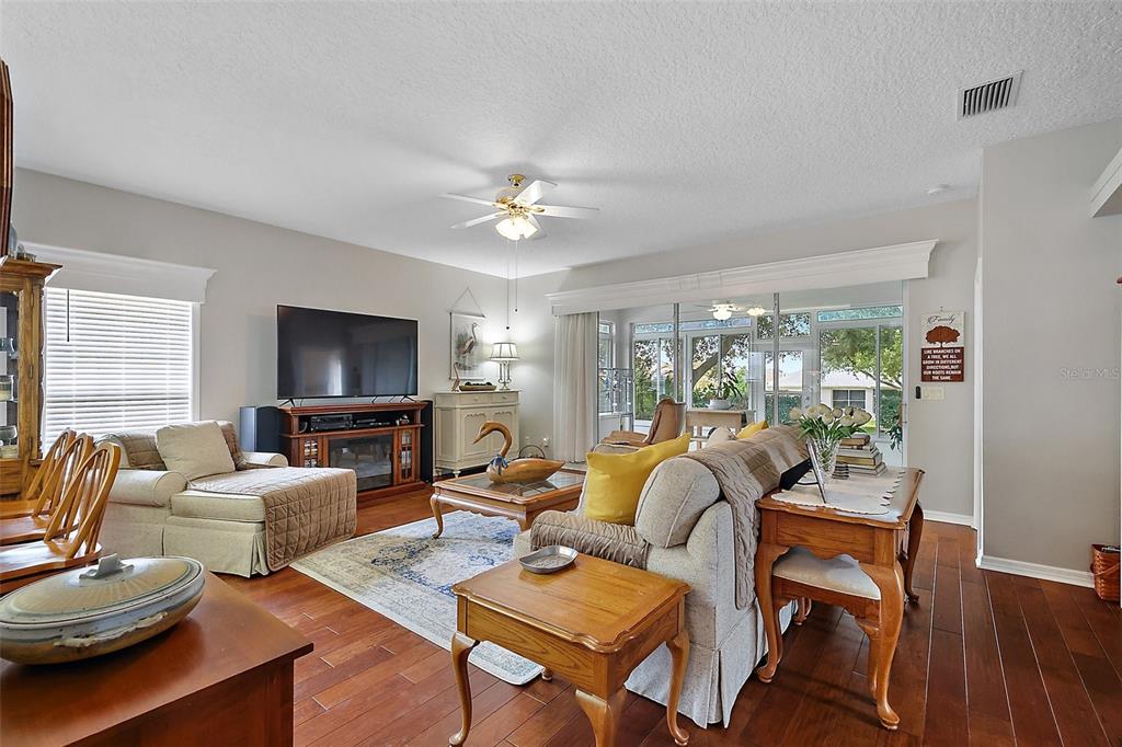 3584 Tropical Seas Loop Tavares, FL 32778 - Photo 6 of 49 a living room with furniture a flat screen tv and a large window
