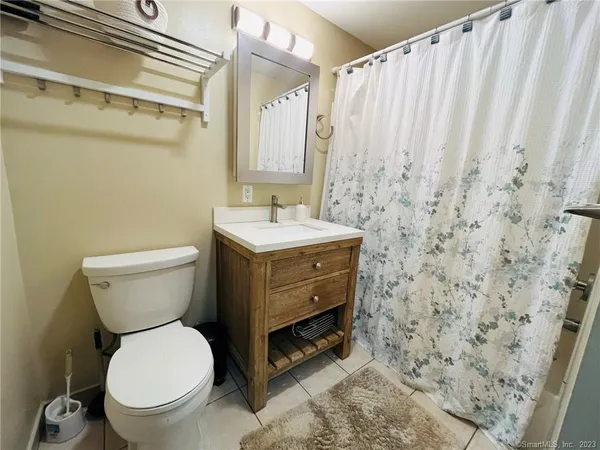a bathroom with a toilet a sink and a shower curtain