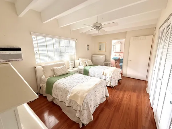 a bedroom with two beds and wooden floors