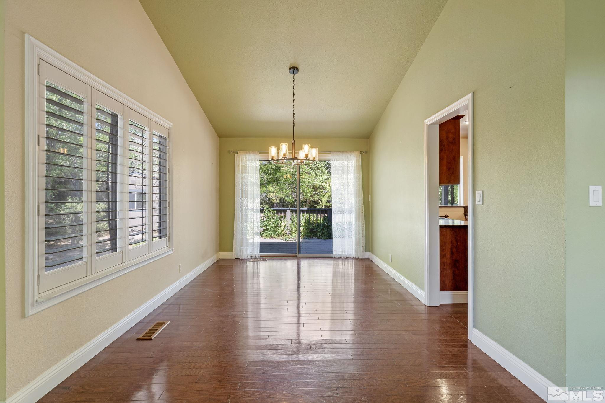 2197 Solitude Drive Reno, NV 89511 - Photo 11 of 40 a view of an empty room with wooden floor and a window