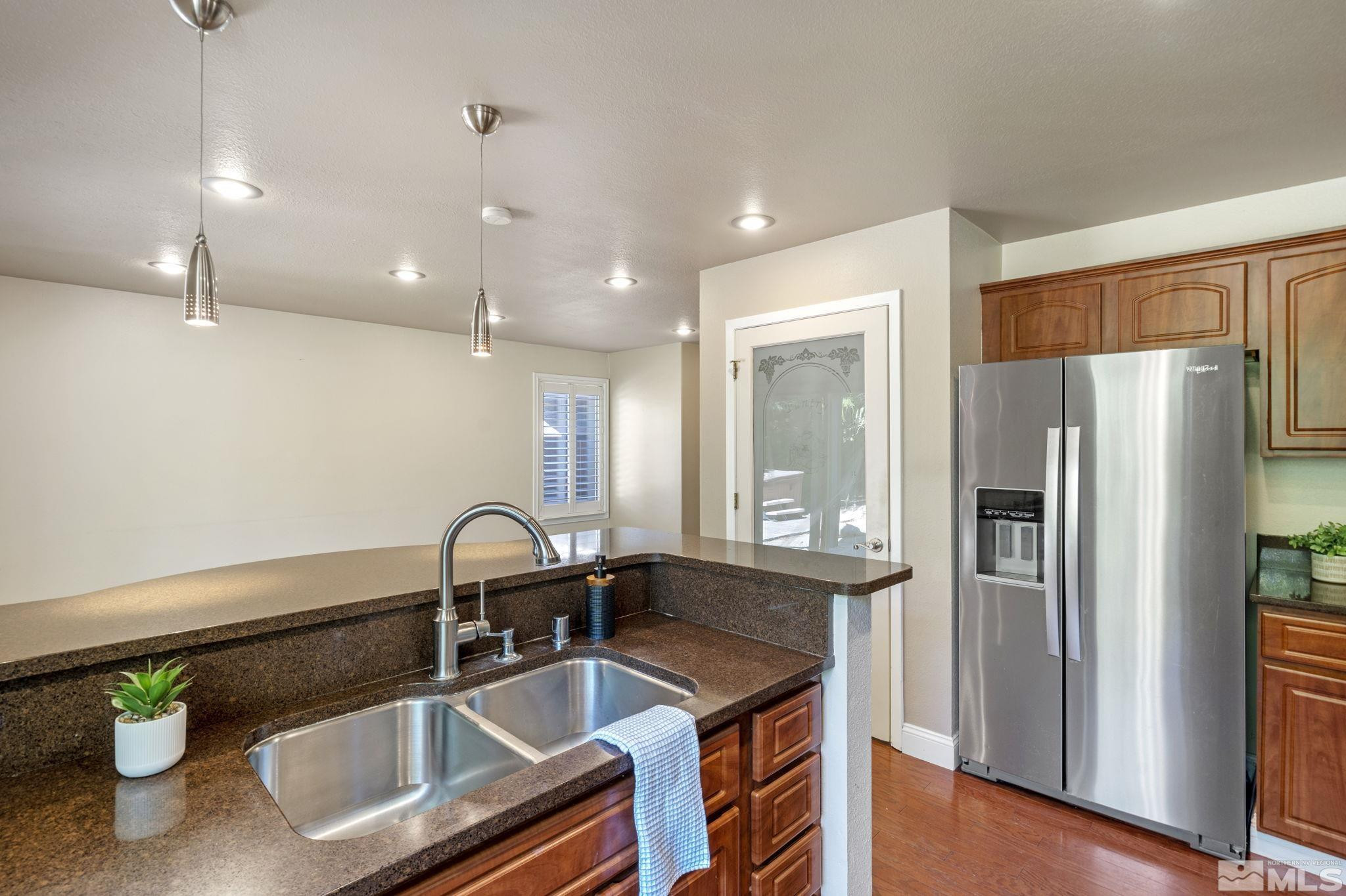 2197 Solitude Drive Reno, NV 89511 - Photo 20 of 40 a kitchen with granite countertop a sink stainless steel appliances and cabinets