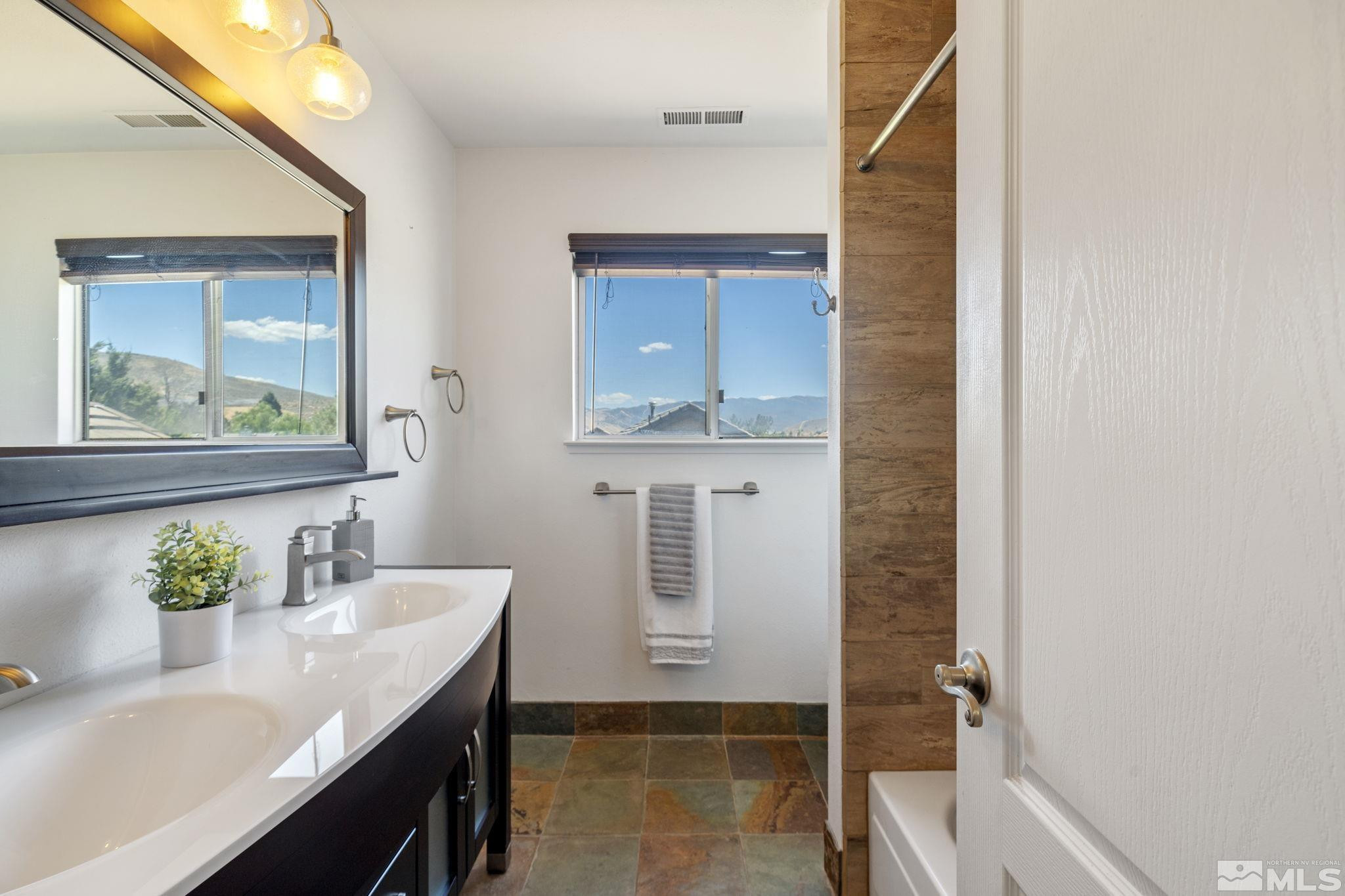 2197 Solitude Drive Reno, NV 89511 - Photo 36 of 40 a bathroom with a sink a mirror and a window