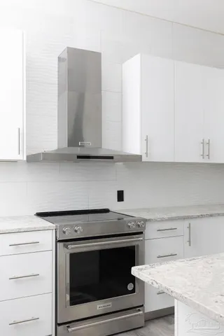 a kitchen with granite countertop white cabinets and white appliances