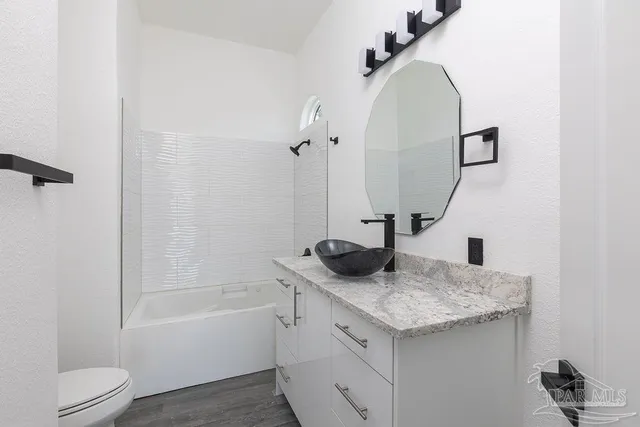 a bathroom with a granite countertop sink toilet and shower
