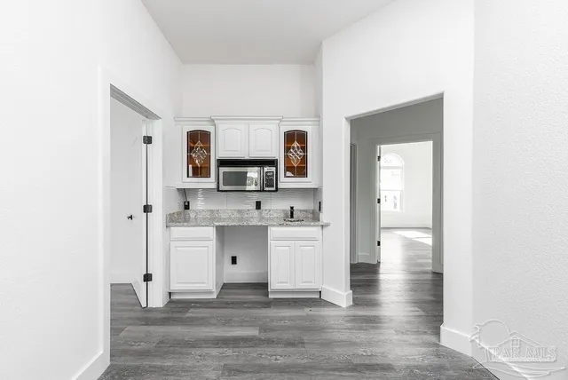 a kitchen with white cabinets and appliances
