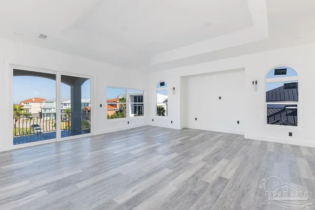 a view of an empty room with wooden floor and closet