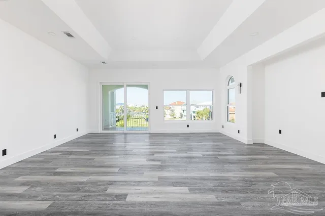 a view of empty room with wooden floor