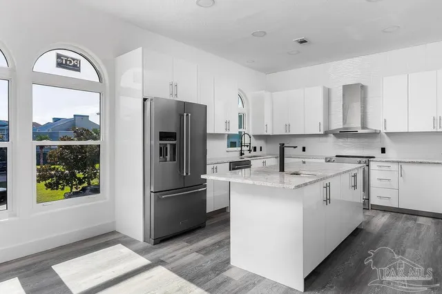 a kitchen with stainless steel appliances granite countertop a refrigerator and a stove