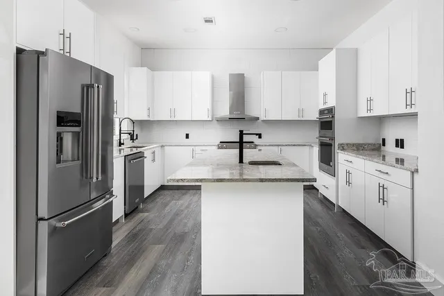 a kitchen with white cabinets and stainless steel appliances