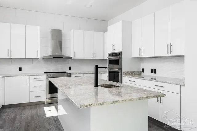 a kitchen with granite countertop white cabinets and white appliances