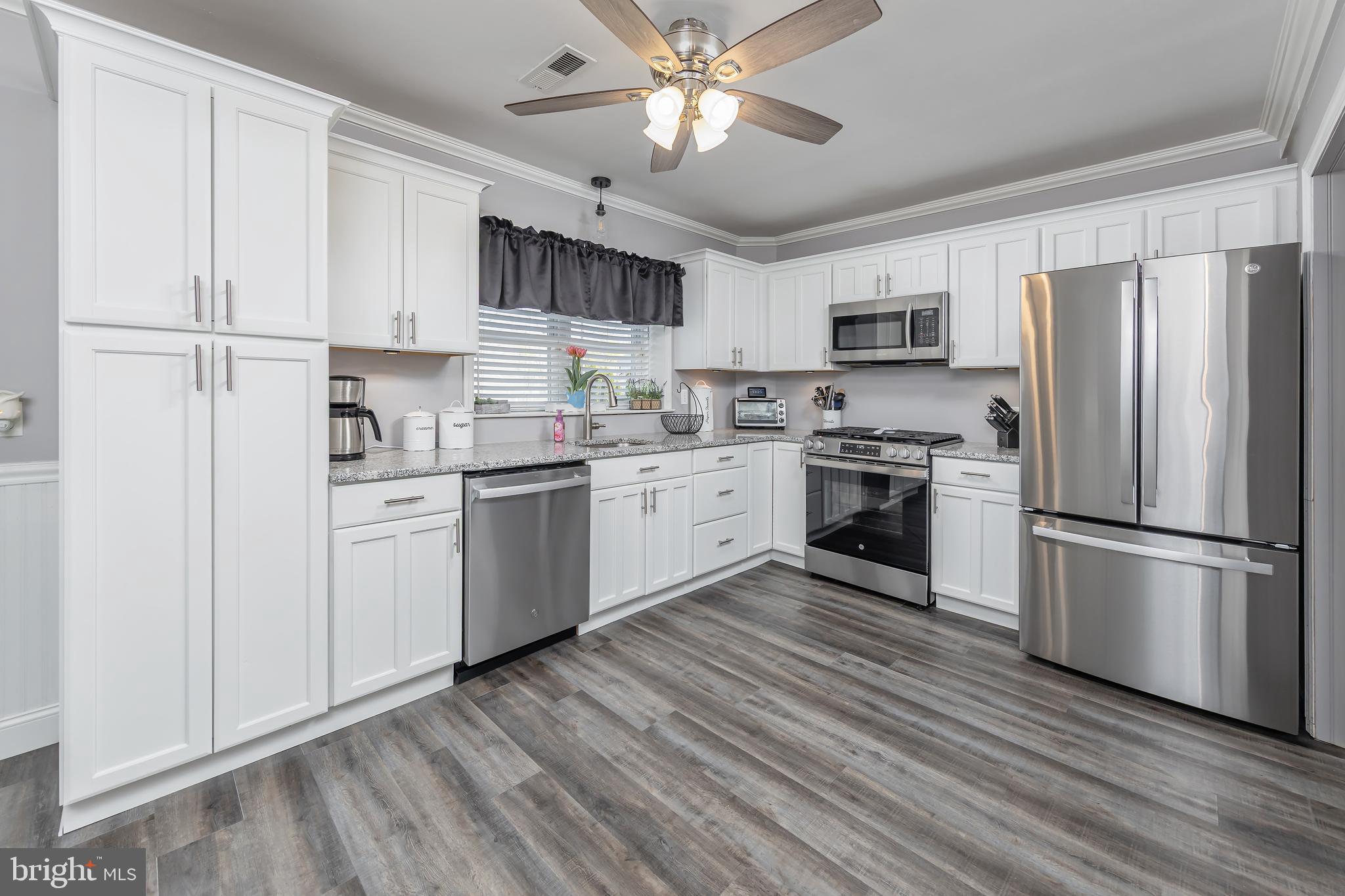 303 Main Street Mantua, NJ 08051 - Photo 7 of 50 a kitchen with stainless steel appliances granite countertop a refrigerator a stove a sink dishwasher and a refrigerator with wooden floor
