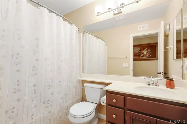 a bathroom with a toilet a sink and a mirror