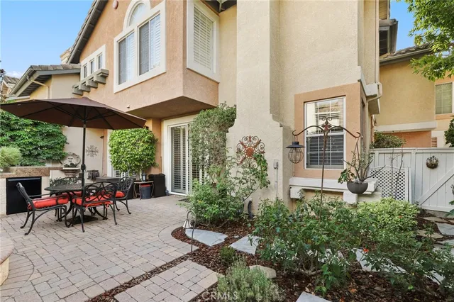 a view of a patio with table and chairs under an umbrella