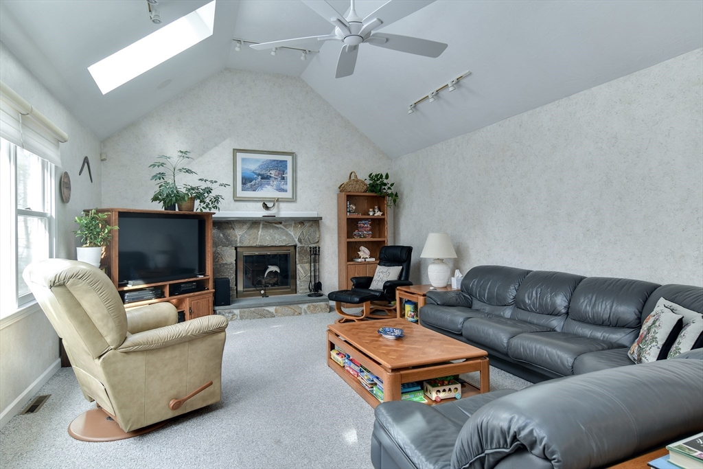 10 Sundance Way Natick, MA 01760 - Photo 13 of 40 a living room with furniture a flat screen tv and a fireplace