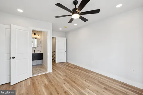 an empty room with closet and a ceiling fan