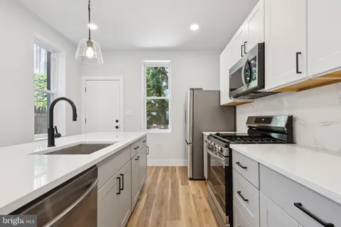 a kitchen with stainless steel appliances granite countertop a sink stove and cabinets