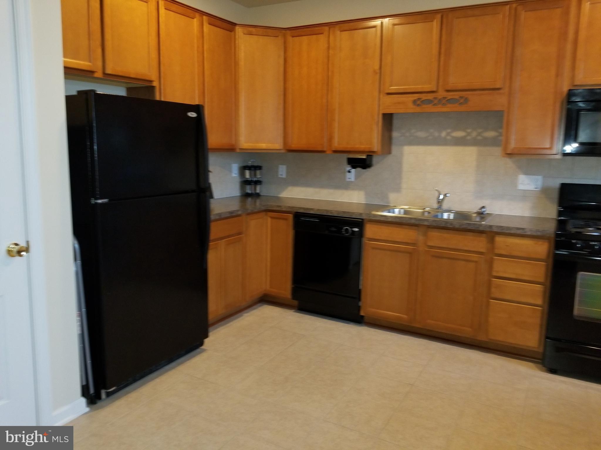 a kitchen with black cabinets and appliances