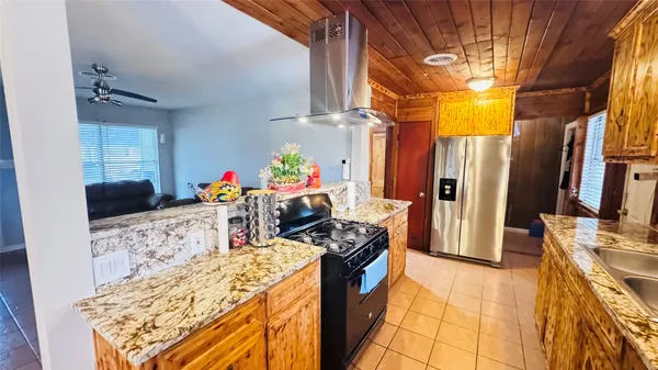 a kitchen with stainless steel appliances kitchen island granite countertop a refrigerator and a stove