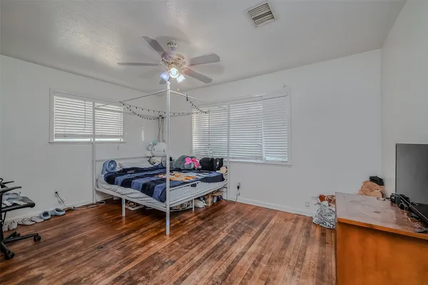 a room with wooden floor and pool table windows