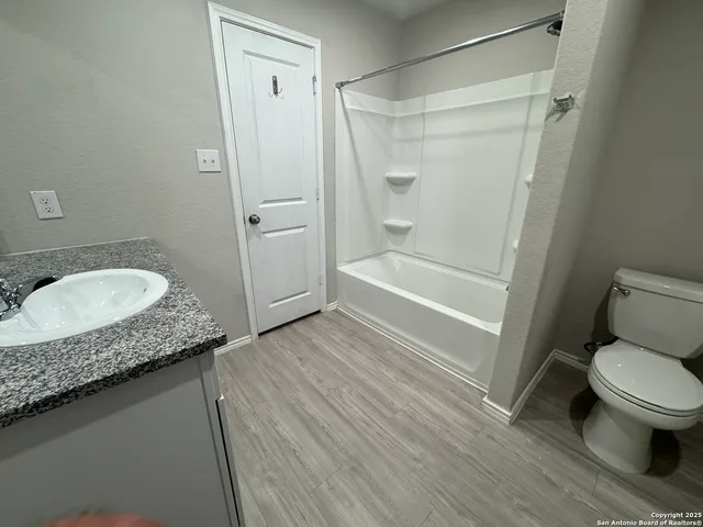 a bathroom with a granite countertop sink toilet and shower