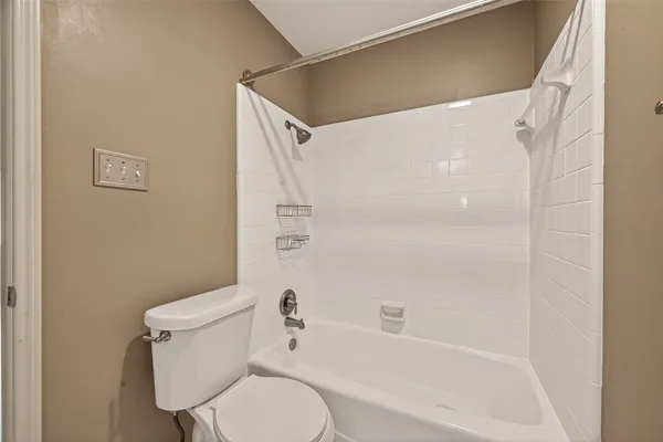 a white toilet sitting next to a bath tub