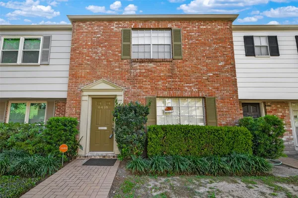 a brick building with potted plants in front of door
