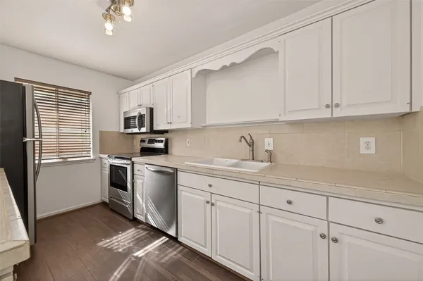 a kitchen with granite countertop white cabinets and white appliances