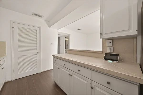 a kitchen with white cabinets and sink