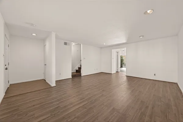a view of an empty room with wooden floor