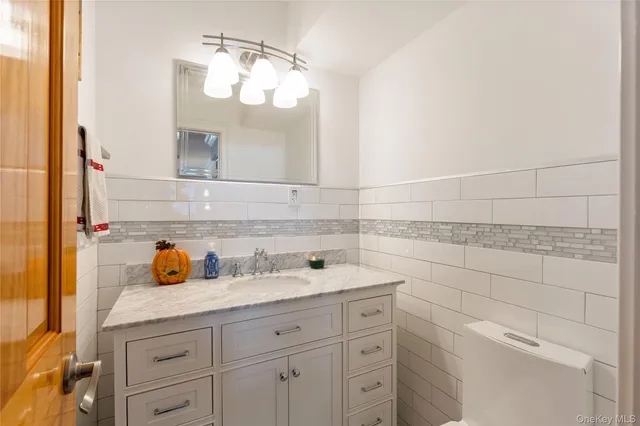 a bathroom with a granite countertop toilet a sink a mirror and shower