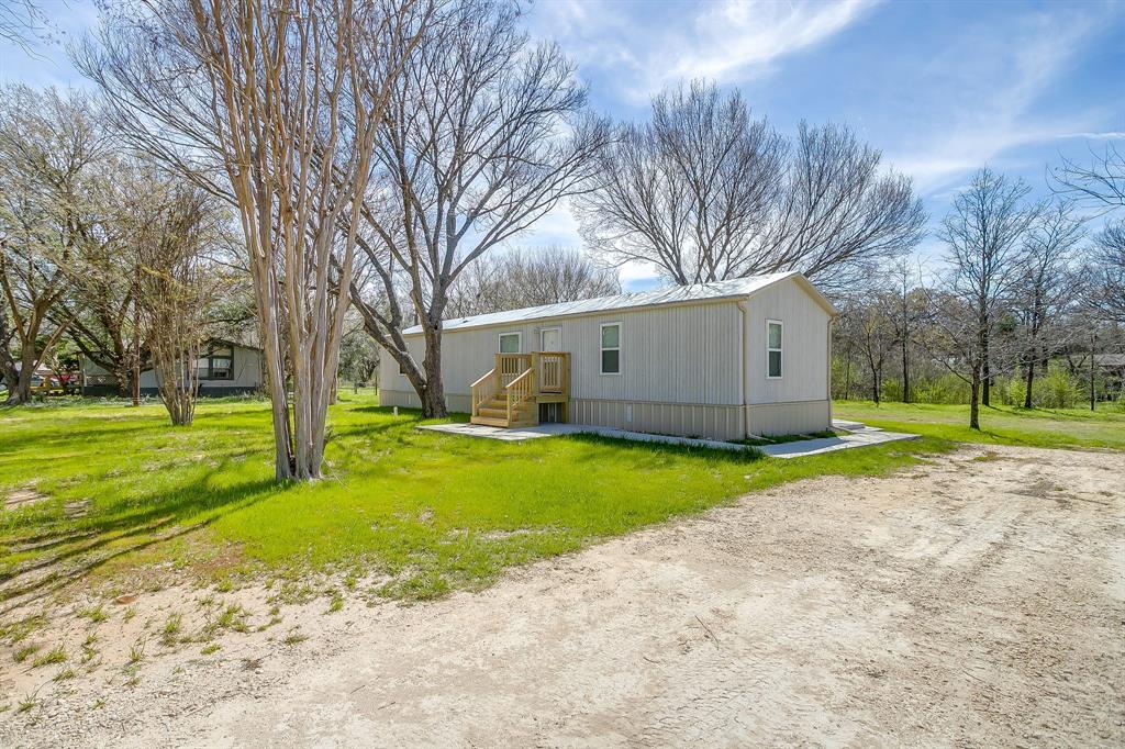 a view of a house with backyard and tree