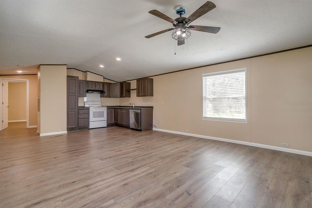 1948 Lariat Lane Burleson, TX 76028 - Photo 35 of 36 an empty room with wooden floor kitchen view and a window