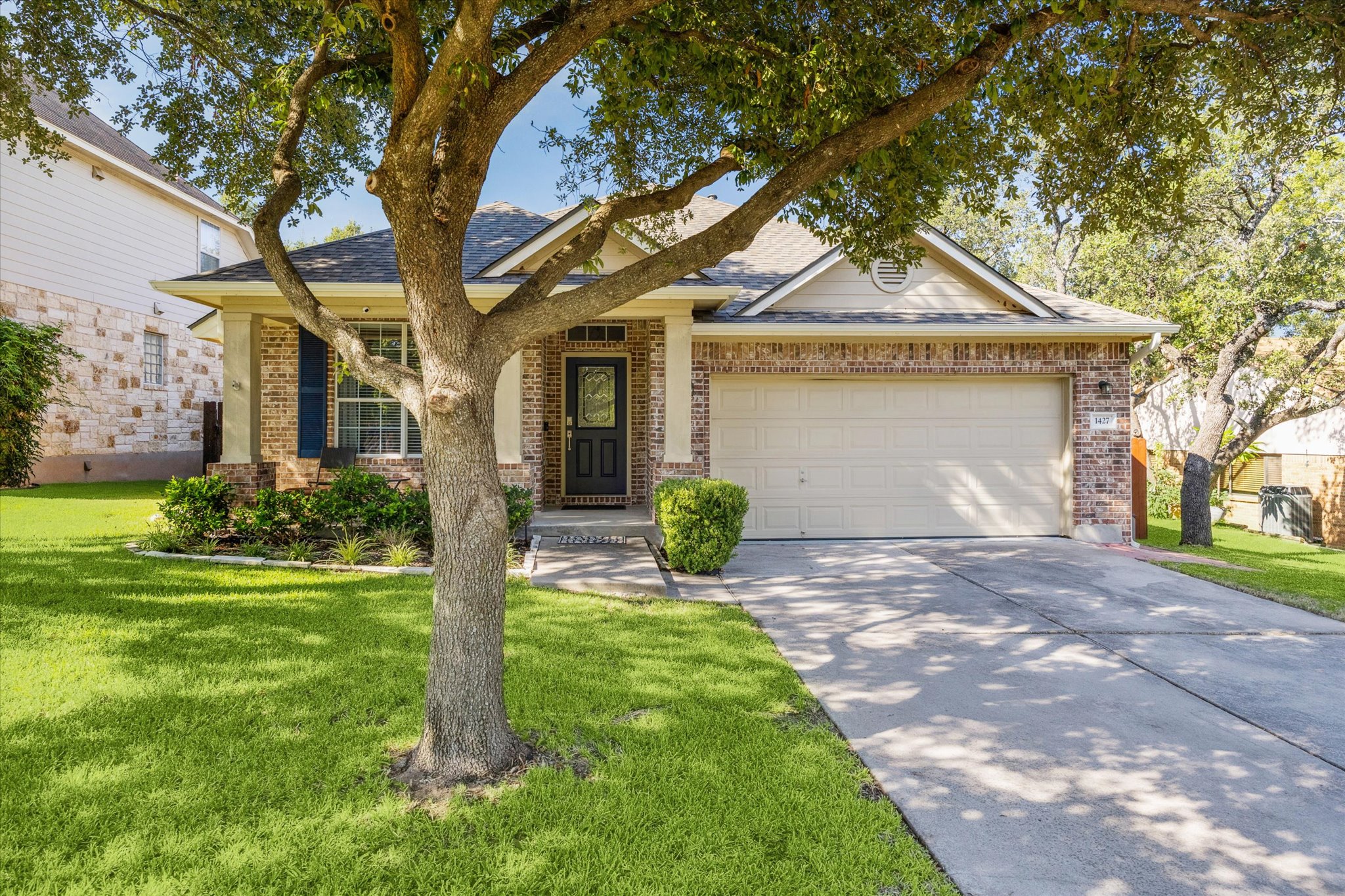 a front view of a house with yard and green space