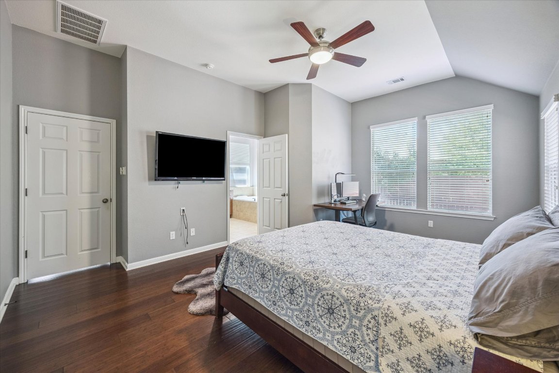 1427 Gorham Street Austin, TX 78758 - Photo 11 of 20 Bedroom with connected bathroom, dark wood finished floors, a desk, and a ceiling fan