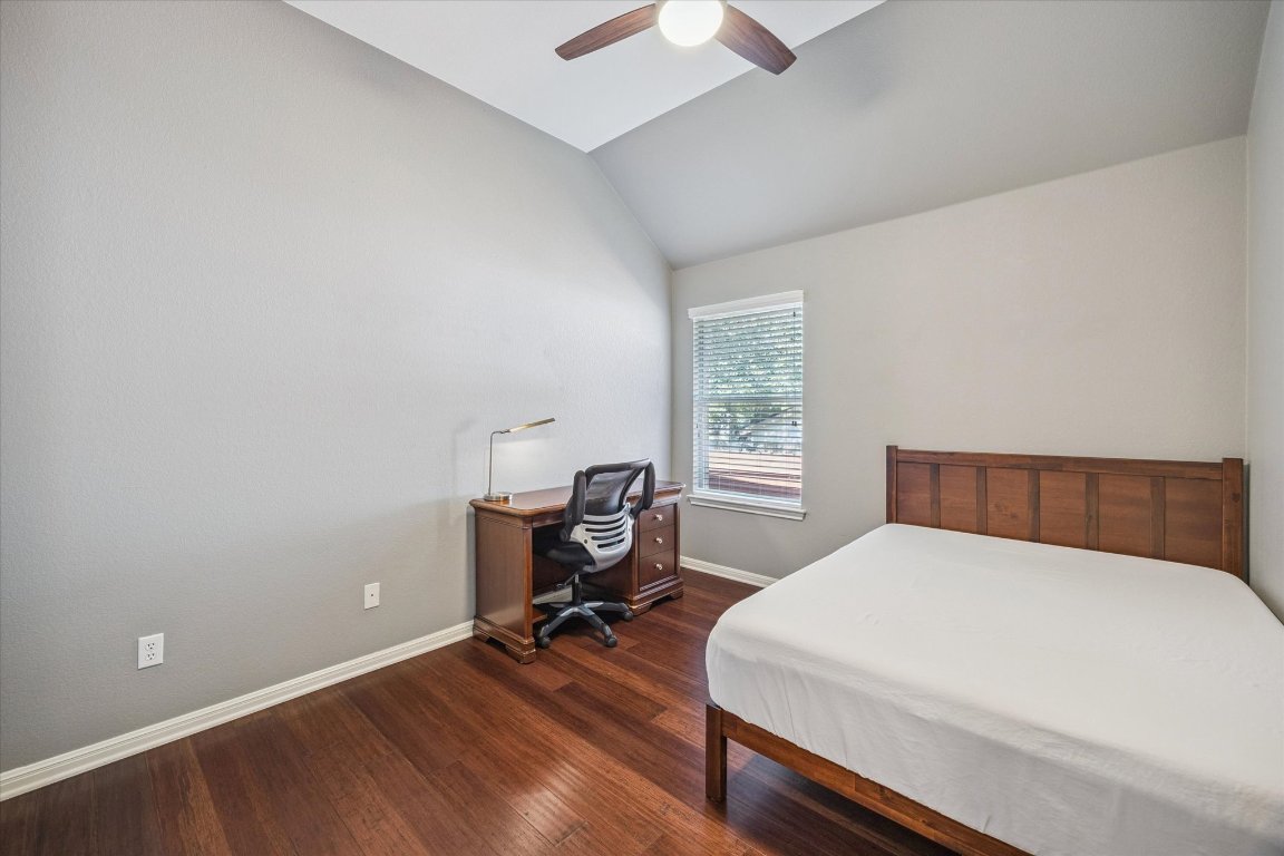 1427 Gorham Street Austin, TX 78758 - Photo 16 of 20 Bedroom with vaulted ceiling, a desk, dark wood-type flooring, and a ceiling fan
