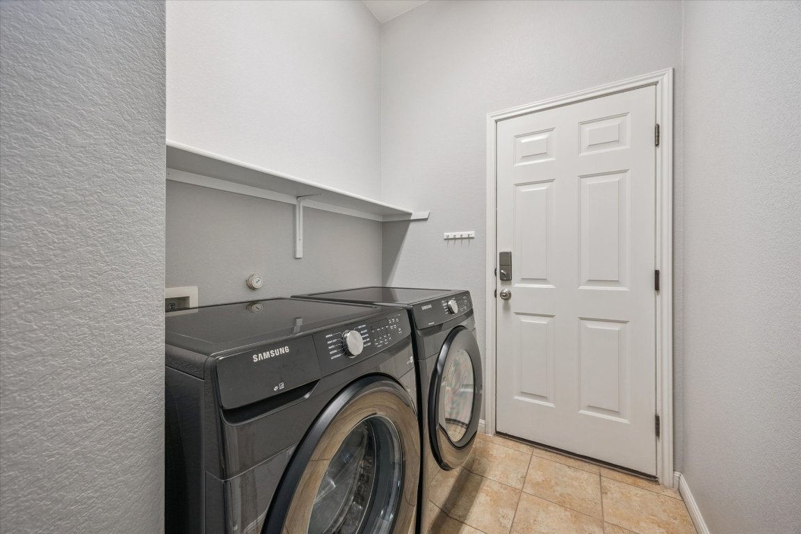 1427 Gorham Street Austin, TX 78758 - Photo 17 of 20 Washroom featuring separate washer and dryer, a textured wall, and light tile patterned flooring