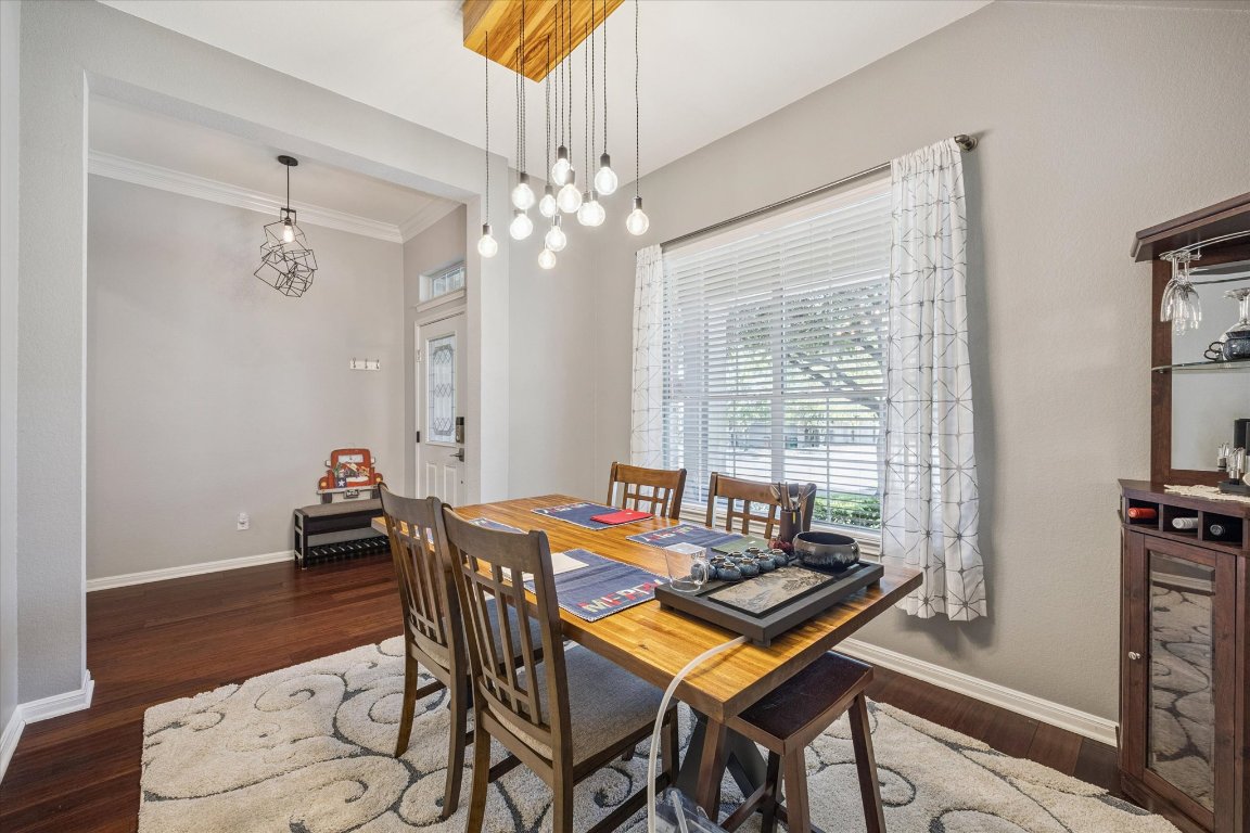 1427 Gorham Street Austin, TX 78758 - Photo 4 of 20 Dining space with dark wood-style flooring, crown molding, and a chandelier