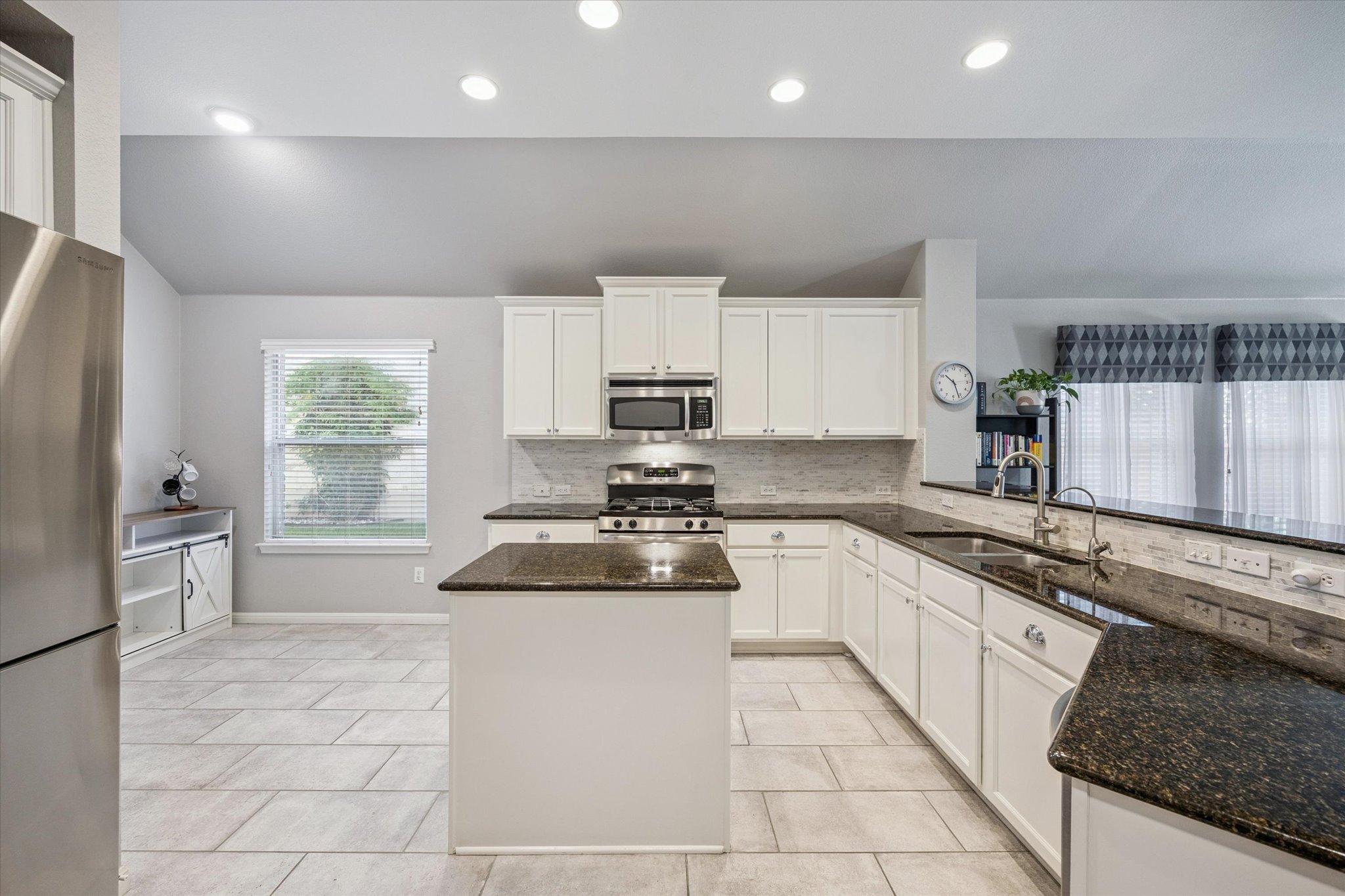 1427 Gorham Street Austin, TX 78758 - Photo 9 of 20 a kitchen with a sink a stove a microwave and cabinets