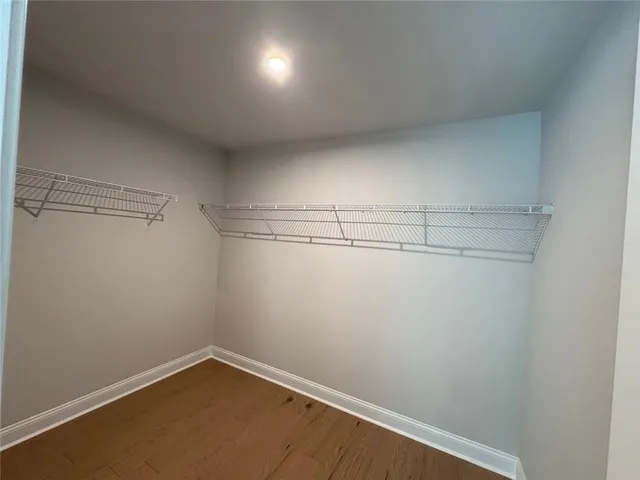 an empty room with windows and ceiling fan