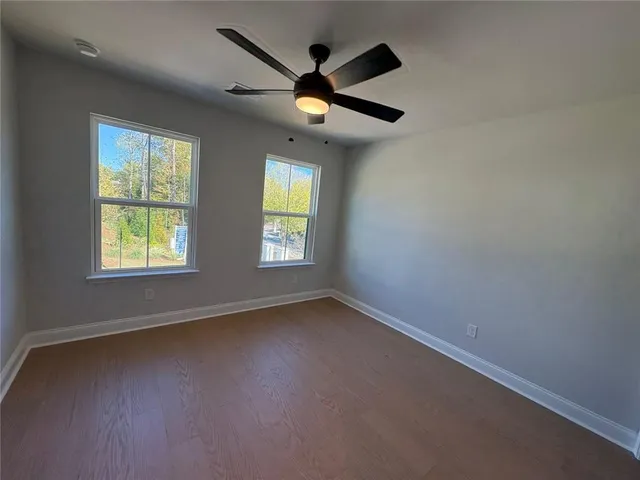 an empty room with a window and a ceiling fan