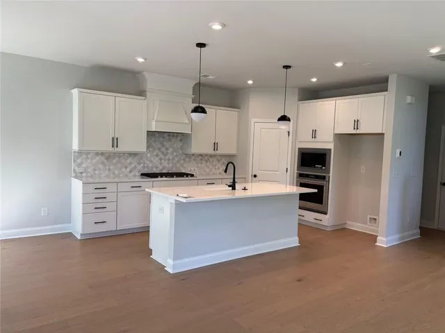 a large kitchen with cabinets and stainless steel appliances
